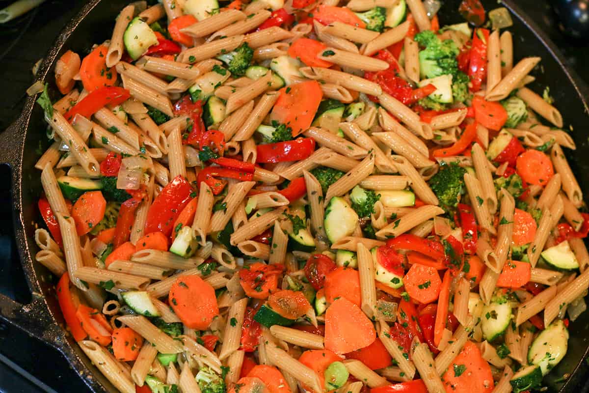 Cast iron pan with a garden vegetable pasta. Fresh veggies, with pasta, fresh herbs, and lemon garlic sauce. 