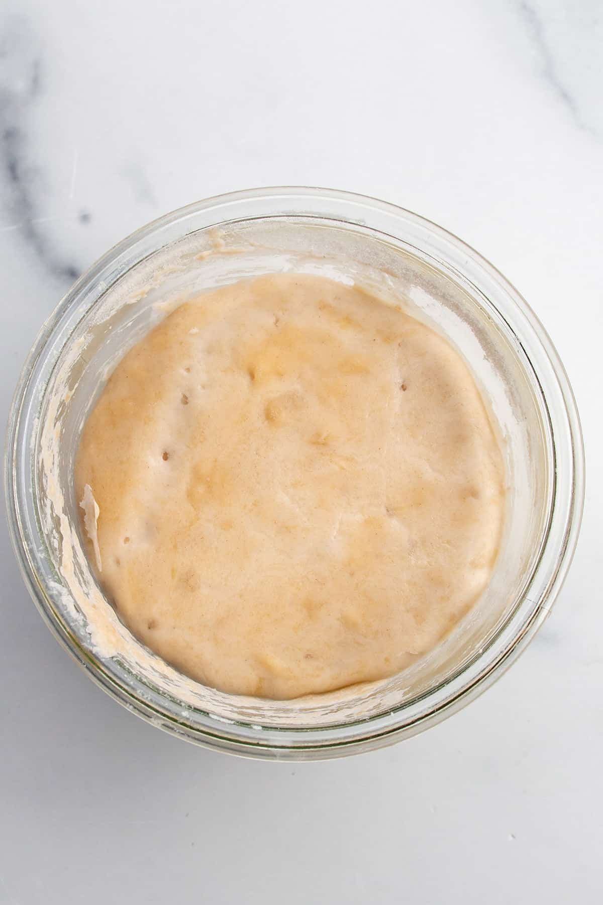 A glass jar with day three of a sourdough starter.