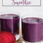 Two small glasses with a purple beet smoothie, fresh beet and frozen blueberries.
