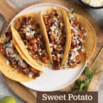 Wood board with four sweet potato black bean tacos.