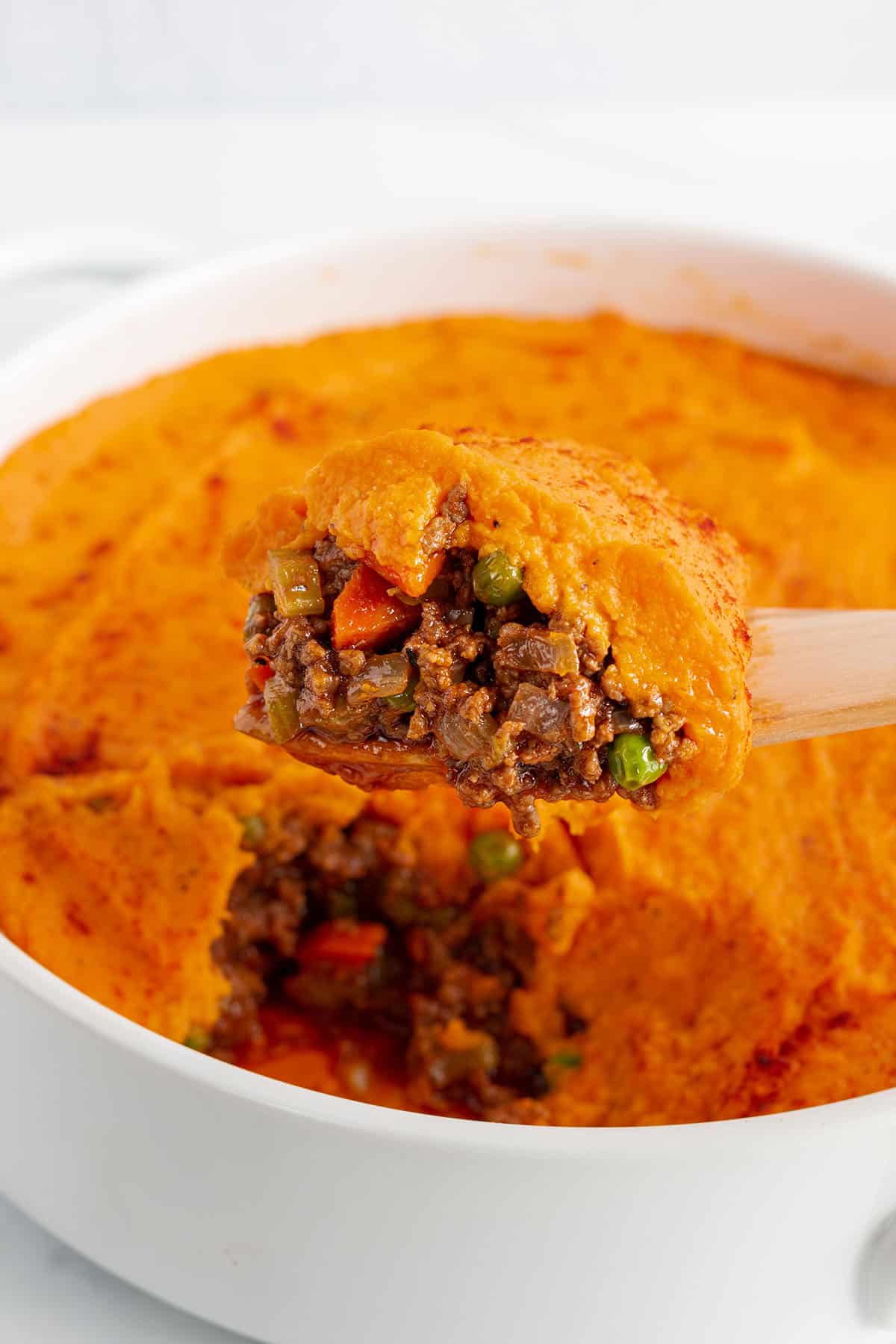 A spatula scooping out a serving of sweet potato Shepherd's Pie.