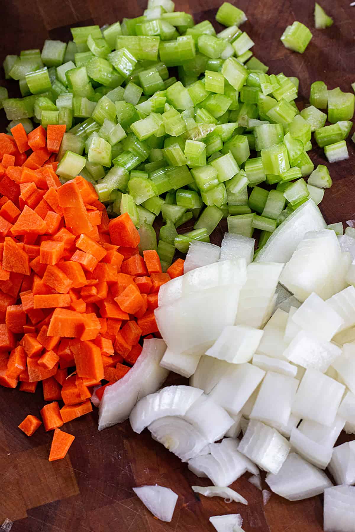 A pile of freshly cut veggies. Carrots, Onions and celery. 