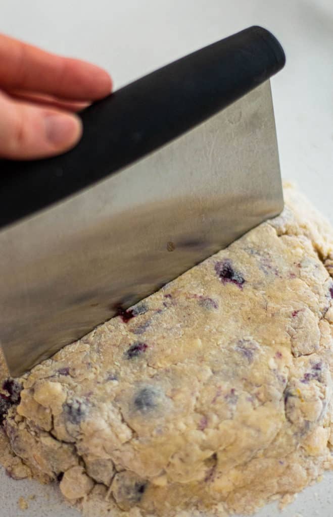 Cutting homemade scones with a bench scraper.