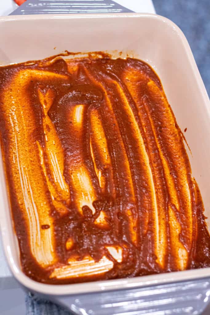 Baking dish covered with homemade enchilada sauce.