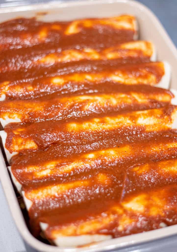 Tortillas topped with homemade enchilada sauce.