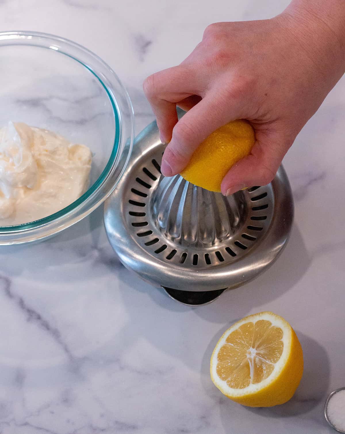 A lemon being squeezed on a lemon juicer.