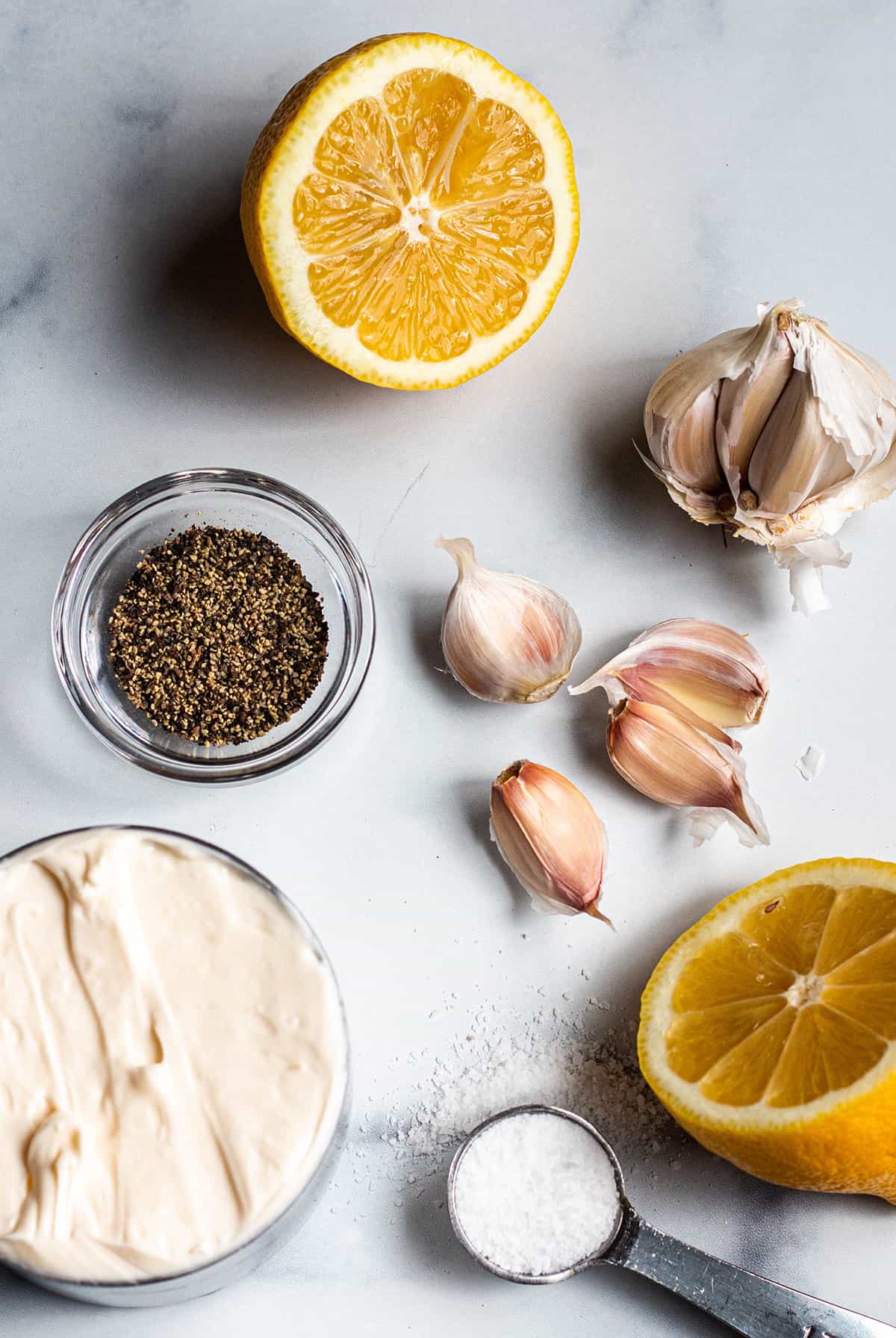 Ingredients for lemon garlic aioli: mayonnaise, lemon, garlic, salt, and pepper.