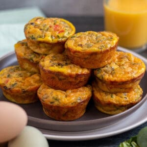 A plate with a stack of sourdough breakfast bites filled with fresh veggies.