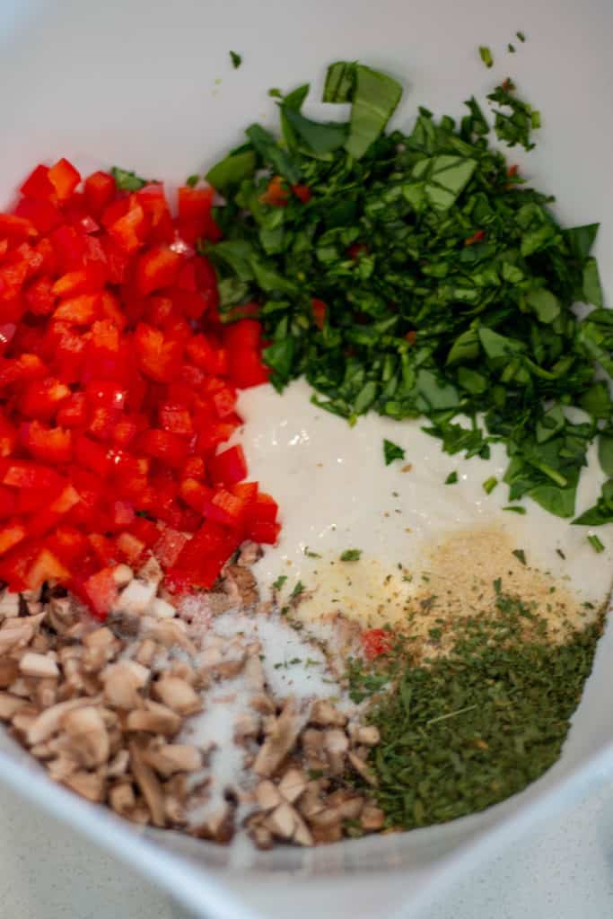 bowl with sourdough starter, seasoning, peppers, spinach and mushrooms.