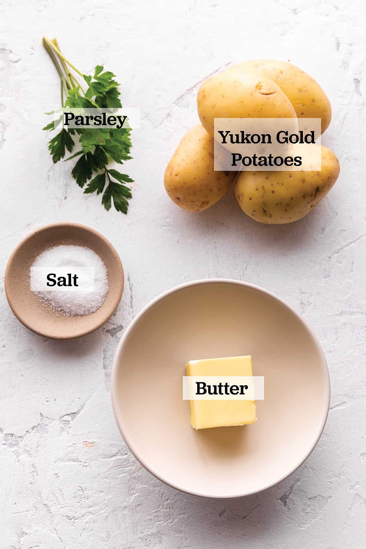 A plate with butter, yukon potatoes, parsley and salt. 
