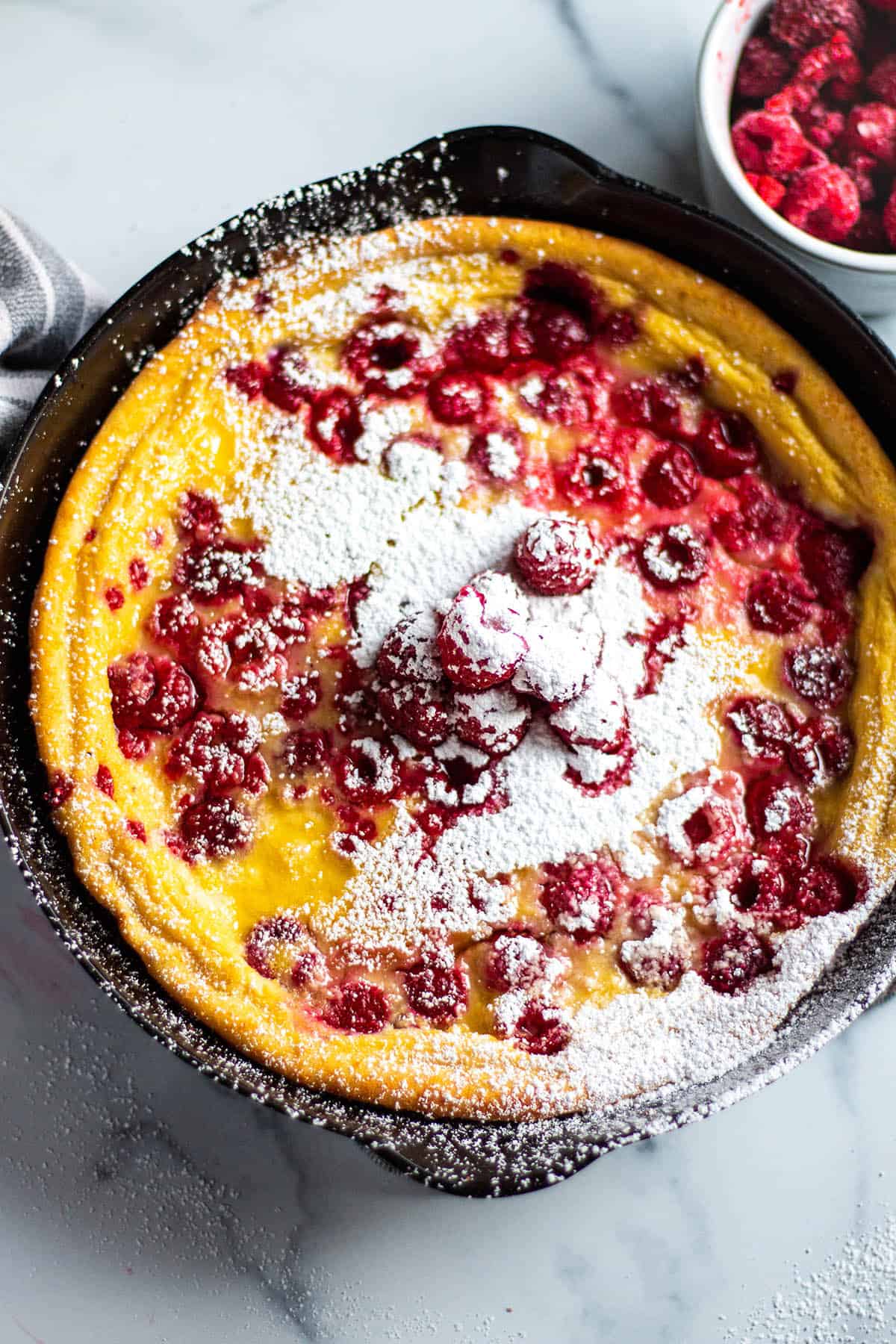 Cast iron with a dutch baby, raspberries and powder sugar