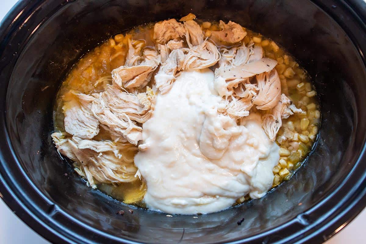 Crock-Pot with shredded chicken, corn, white beans and a homemade roux.