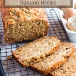 A loaf of bread on a cooling rack with words that say sourdough banana bread.