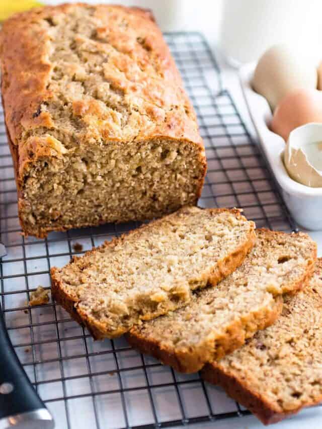 A cooling rack with a loaf of sourdough bread with a few slices cut off. 