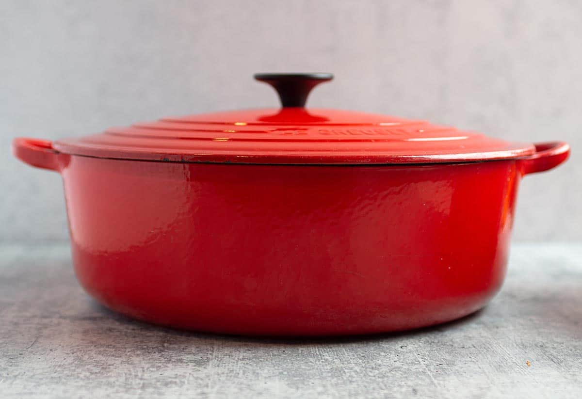 A red round bottom 6.75 Le Creuset Dutch Oven. 