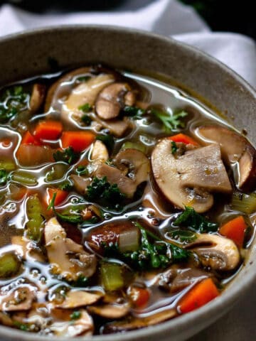 A small bowl filled with a mushroom and veggie soup.