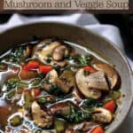 A bowl filled with a soup made of mushrooms and other veggies.