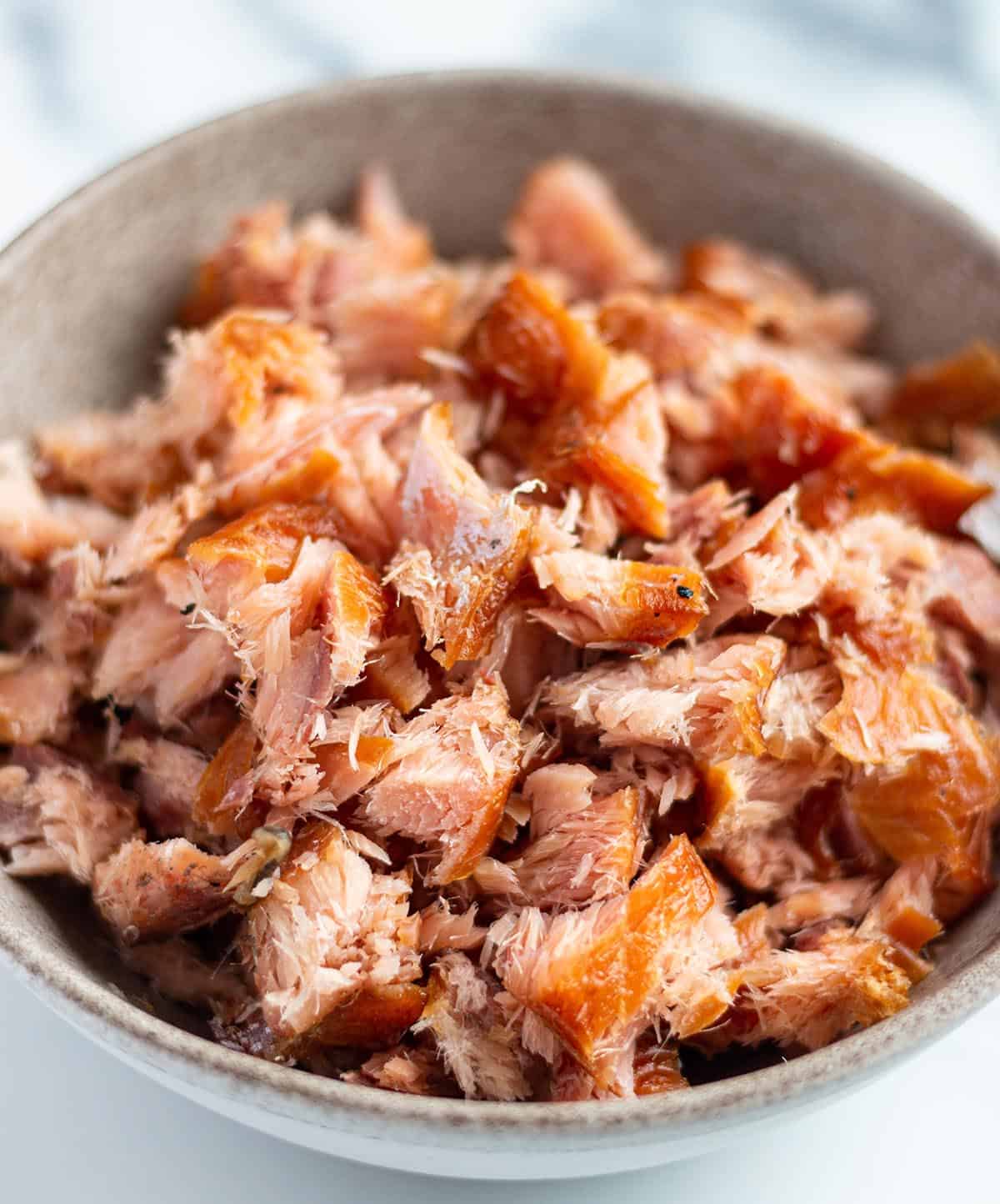 A bowl with broken up pieces of smoked salmon