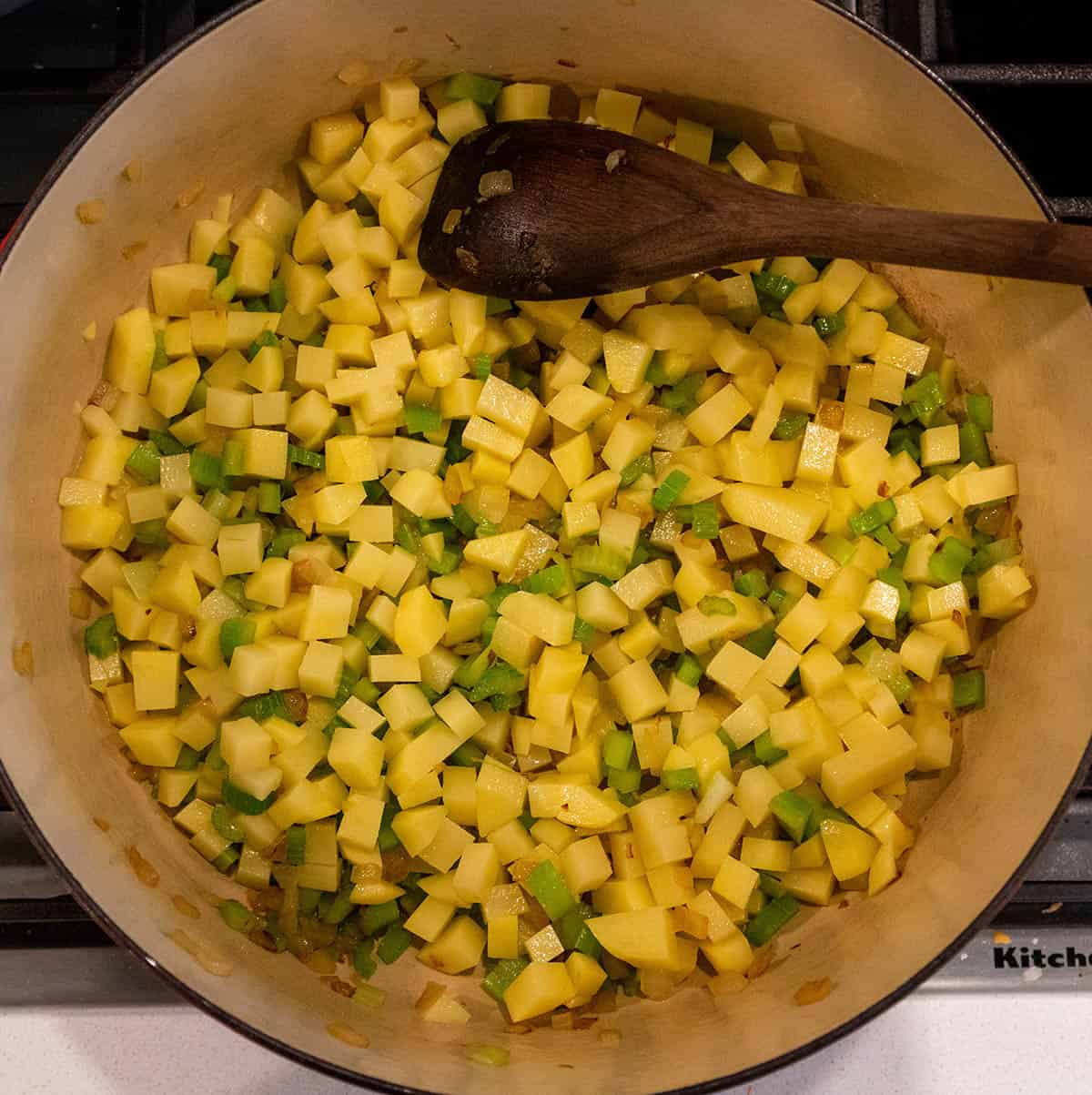 Dutch oven with celery, onions and potatoes sautéing.