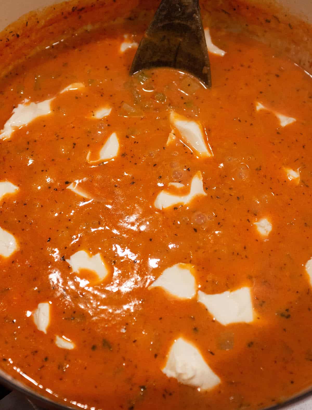 Cream cheese being added into a chowder.