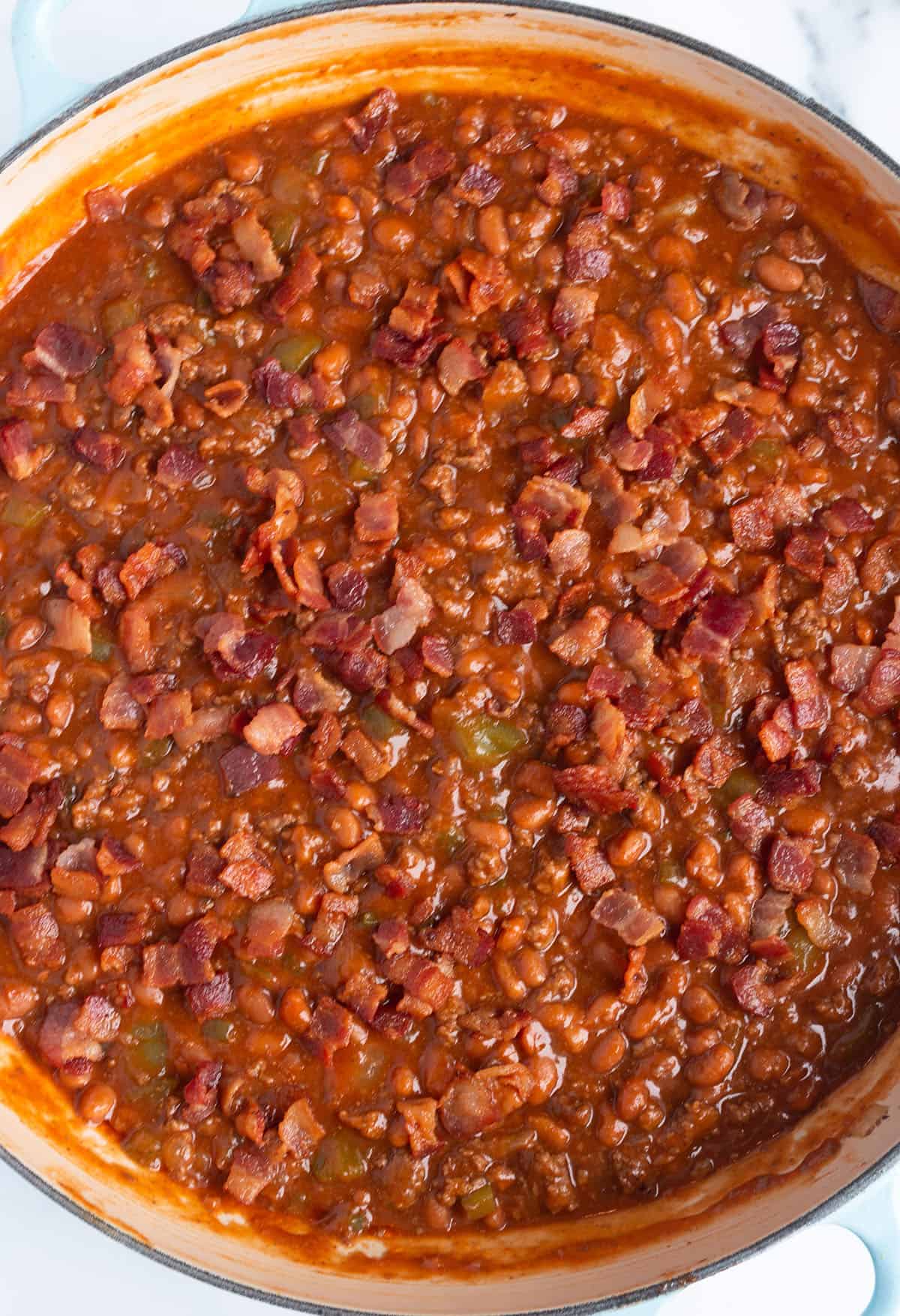 A large skillet with baked beans and ground beef dish.