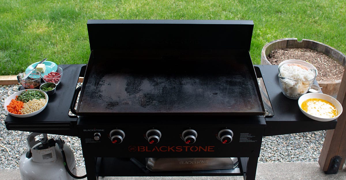A Blackstone griddle with prepared ingredients for fried rice. 