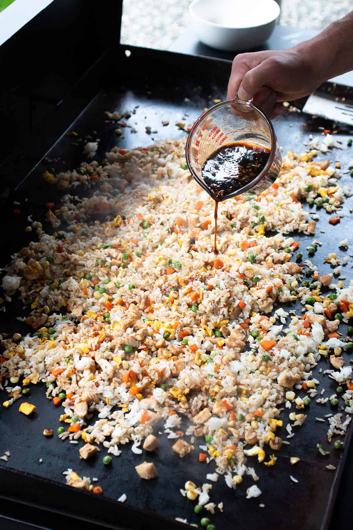Soy Sauce mix being drizzled on the fried rice. 