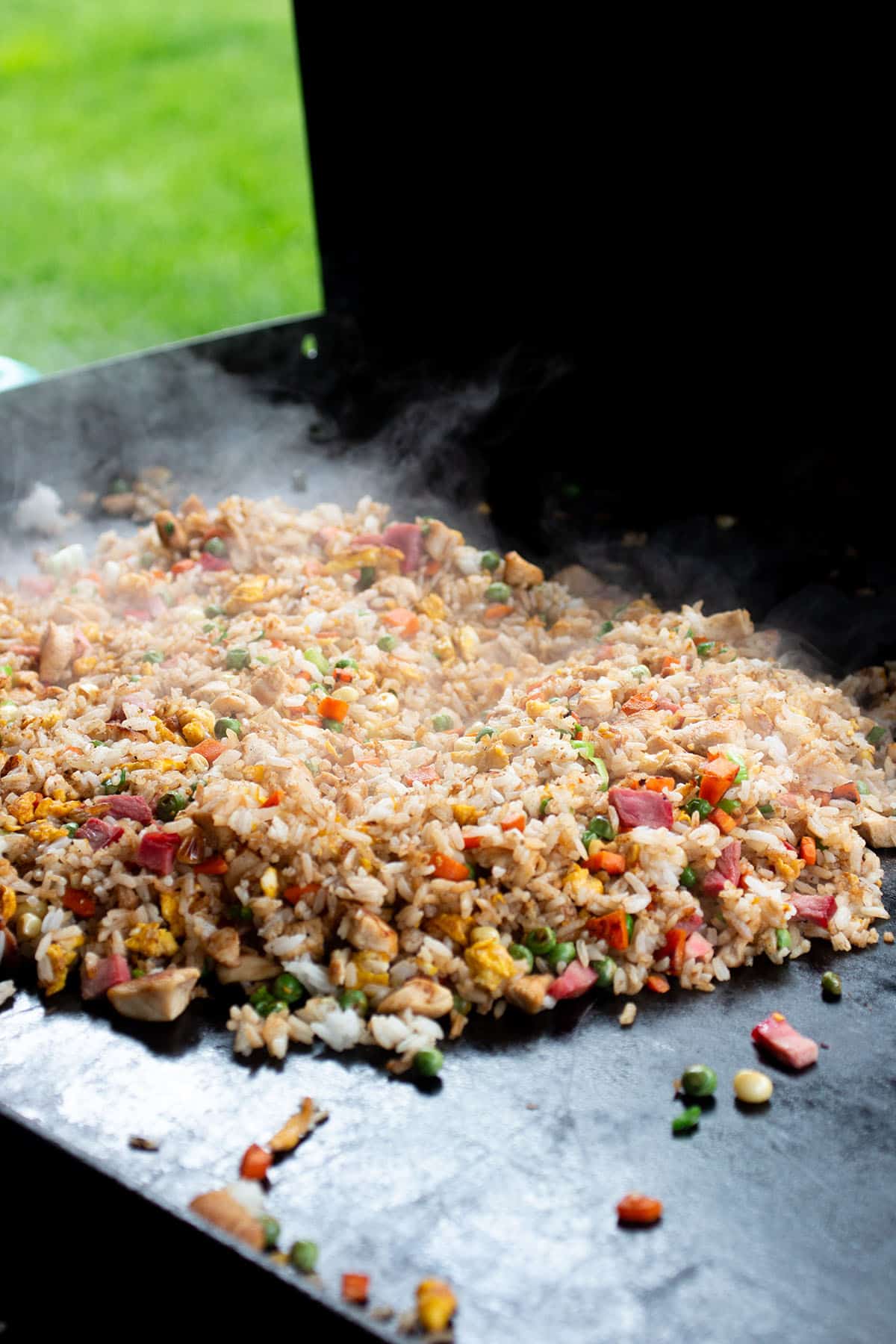 A large pile of homemade fried rice on a Blackstone griddle. 