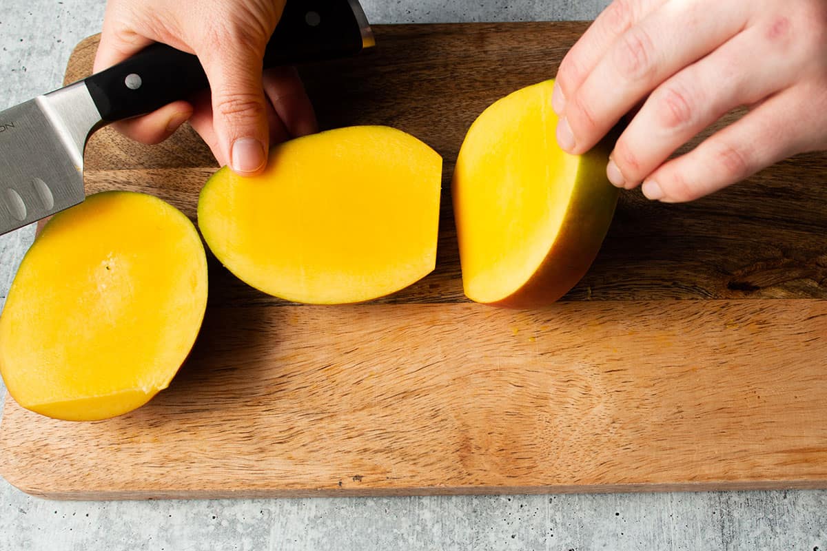 A mango with both sides cut away from the pit. 