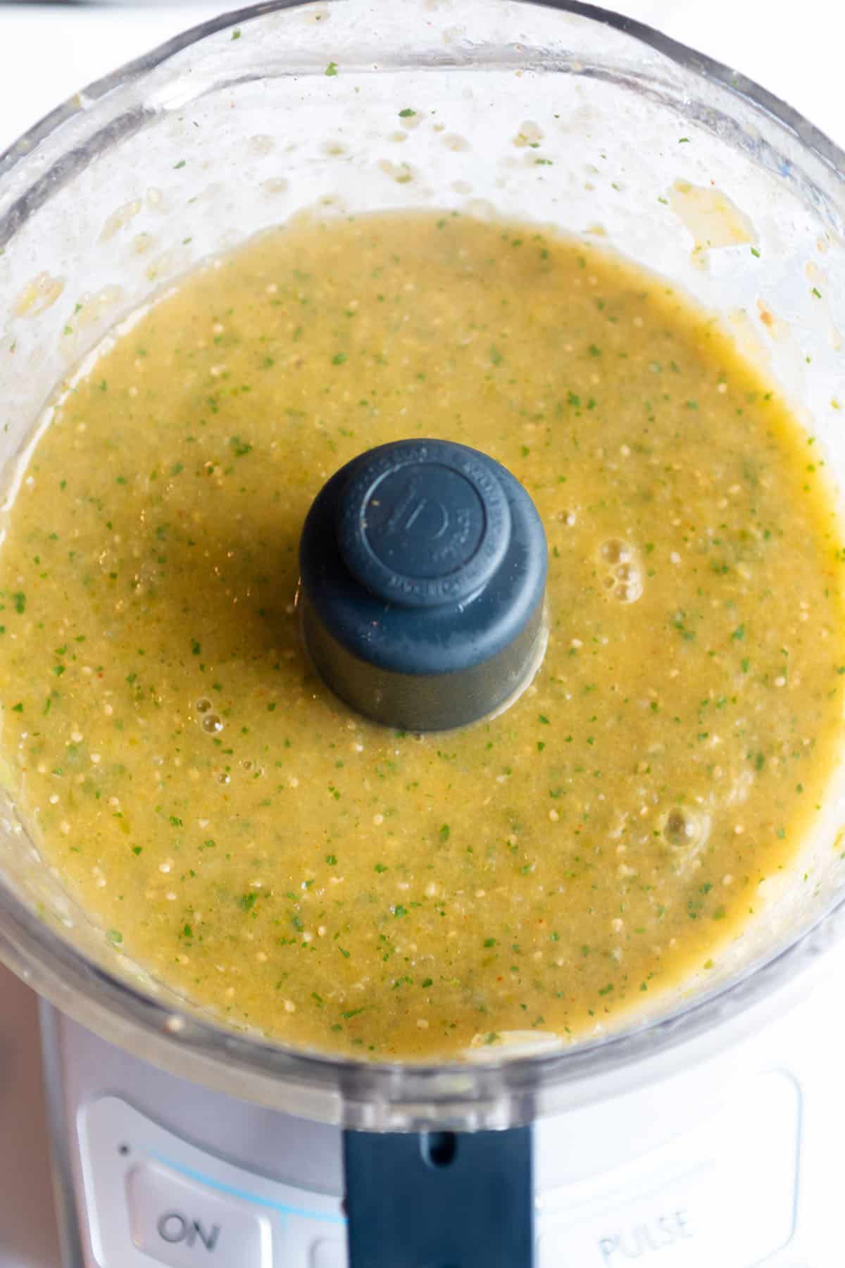 Food processor with a pureed tomatillo green salsa.