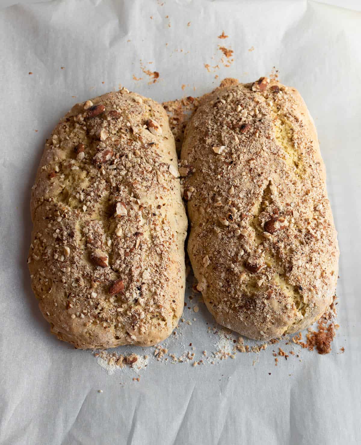 Two freshly baked logs of biscotti with crushed almonds.