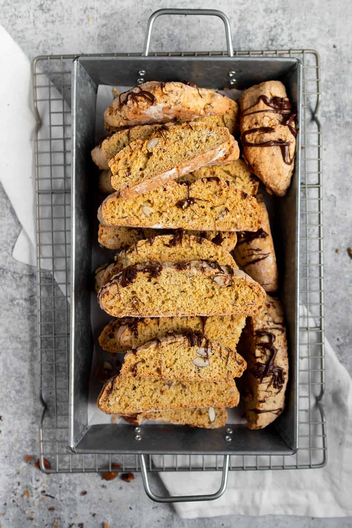 A wire cooling rack with a tray of freshly baked almond biscotti.