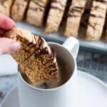 Sourdough almond biscotti being dipped in a cup of coffee.