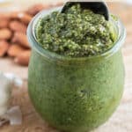 A weck jar with homemade pesto with a spoon scooping some out.