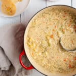 A large dutch oven pot with a creamy clam chowder.