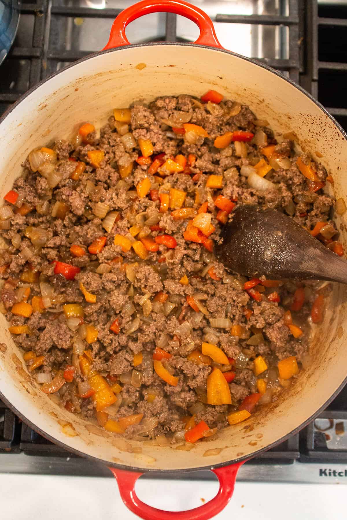 A dutch ovens with sautéed onions, peppers and browned ground beef. 
