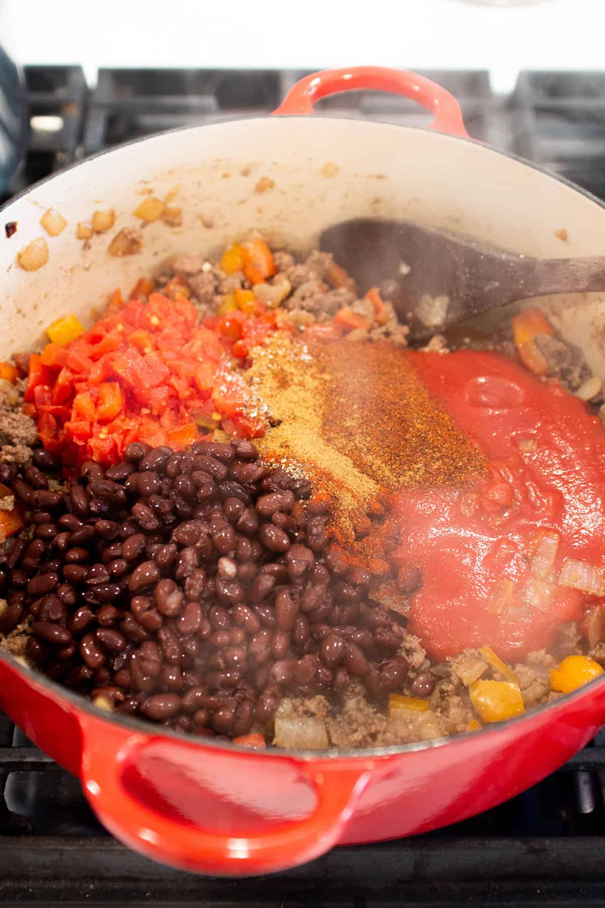 Dutch Oven with browed ground beef, black beans, tomato sauce and spices. 