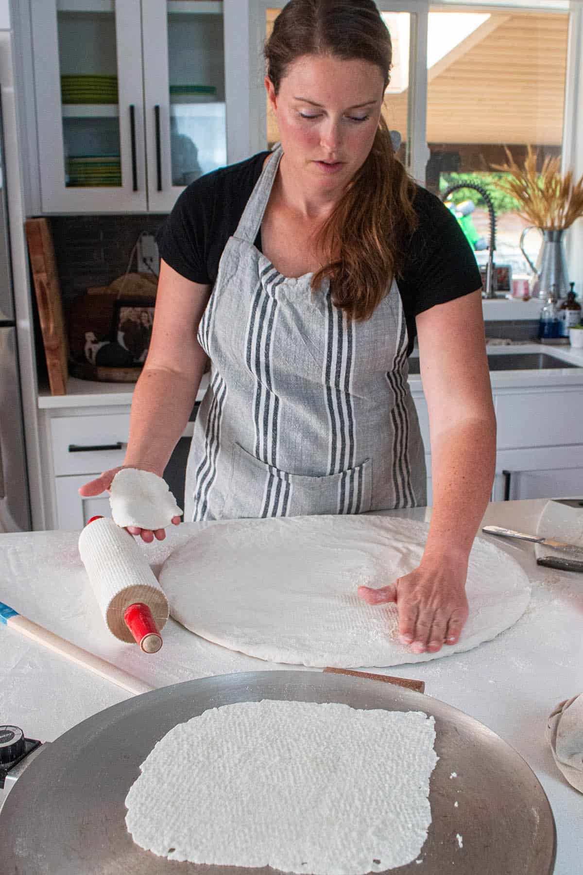 A baker making lefse and flouring the pastry board. 