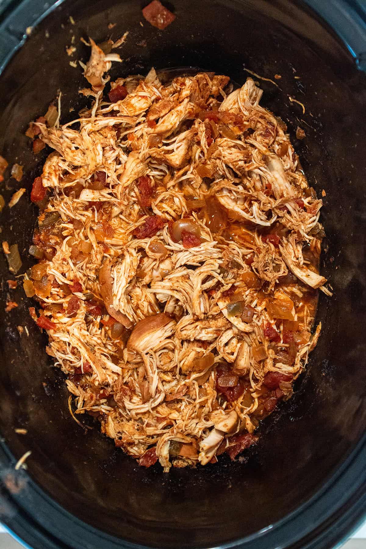 A crockpot full of shredded Mexican chicken.