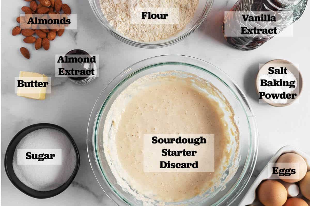 Ingredients all laid out to make sourdough biscotti. Discard, flour, sugar, butter, eggs, almonds, almond extract, vanilla extract, salt and baking powder.