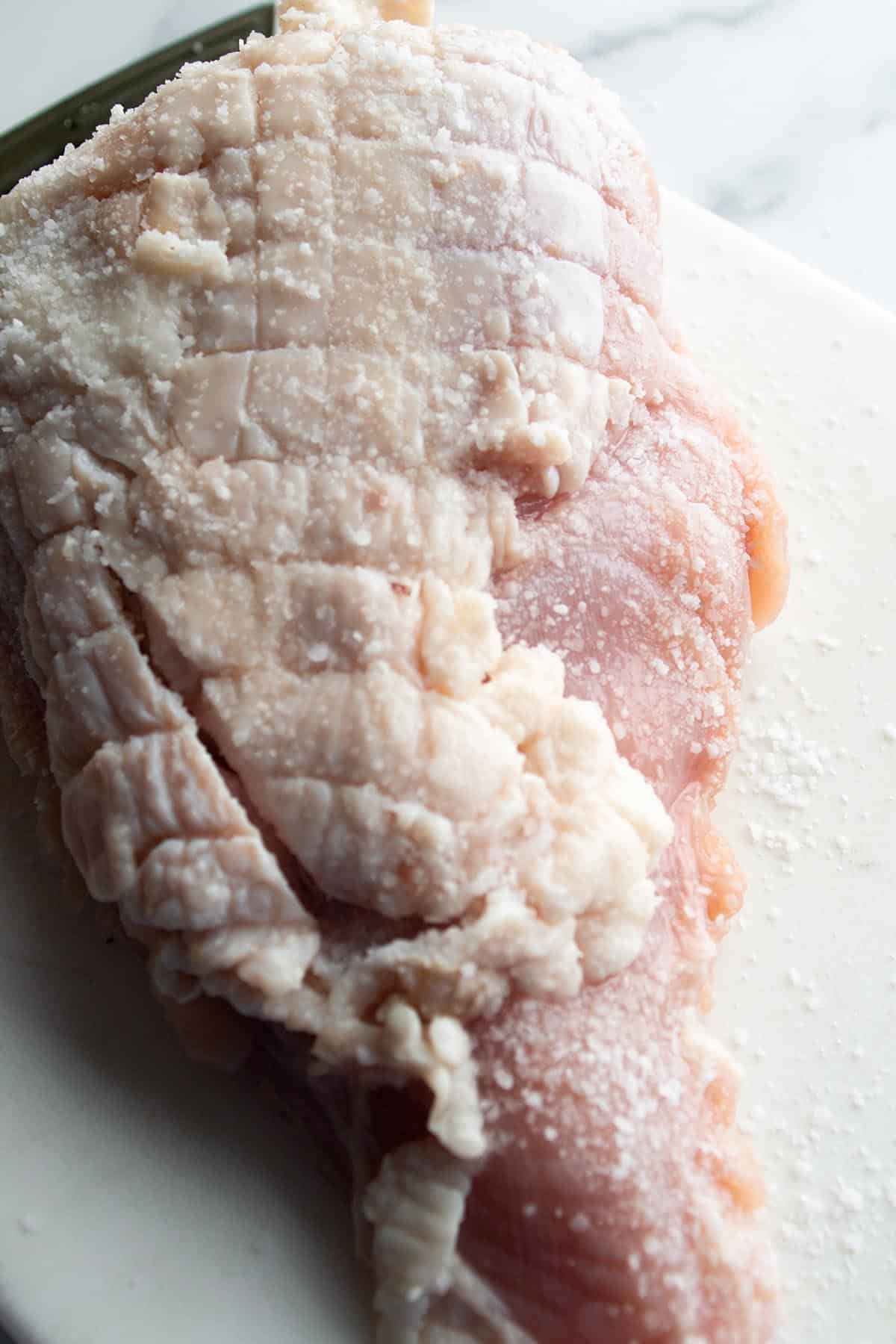 A turkey breast with salt spread over the top.