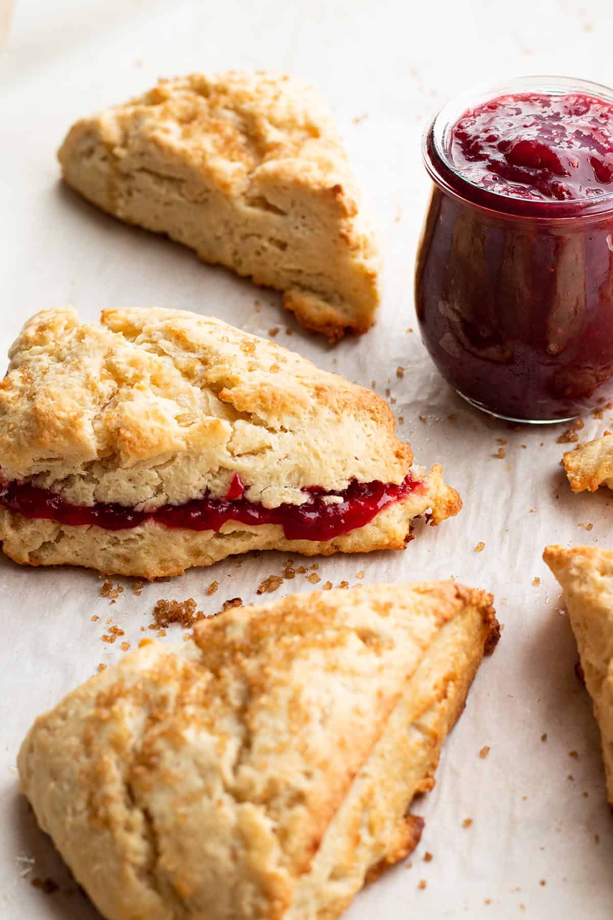 Scones with a jar of raspberry jam. 