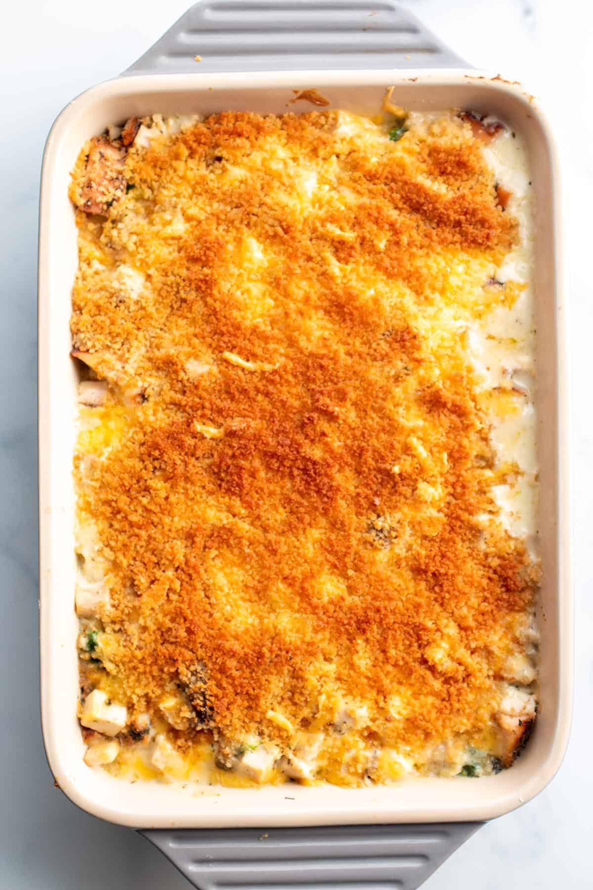 A baking dish with a turkey divan, creamy sauce and toasted panko crumbs.