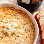 A baking dish with a cheesy crab dip with fresh crab and chives on top.