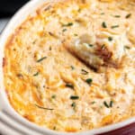 Baking dish with a homemade crab dip topped with fresh crab meat.