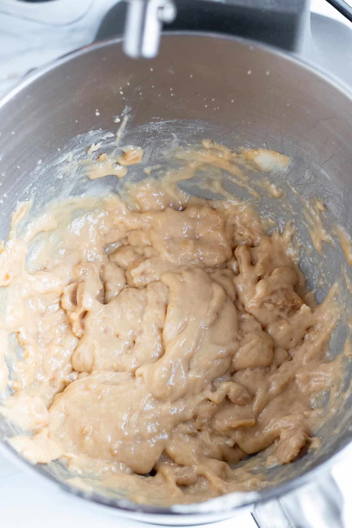 A stand mixer with eggs and Valhalla extra  mixed in the cookie dough.