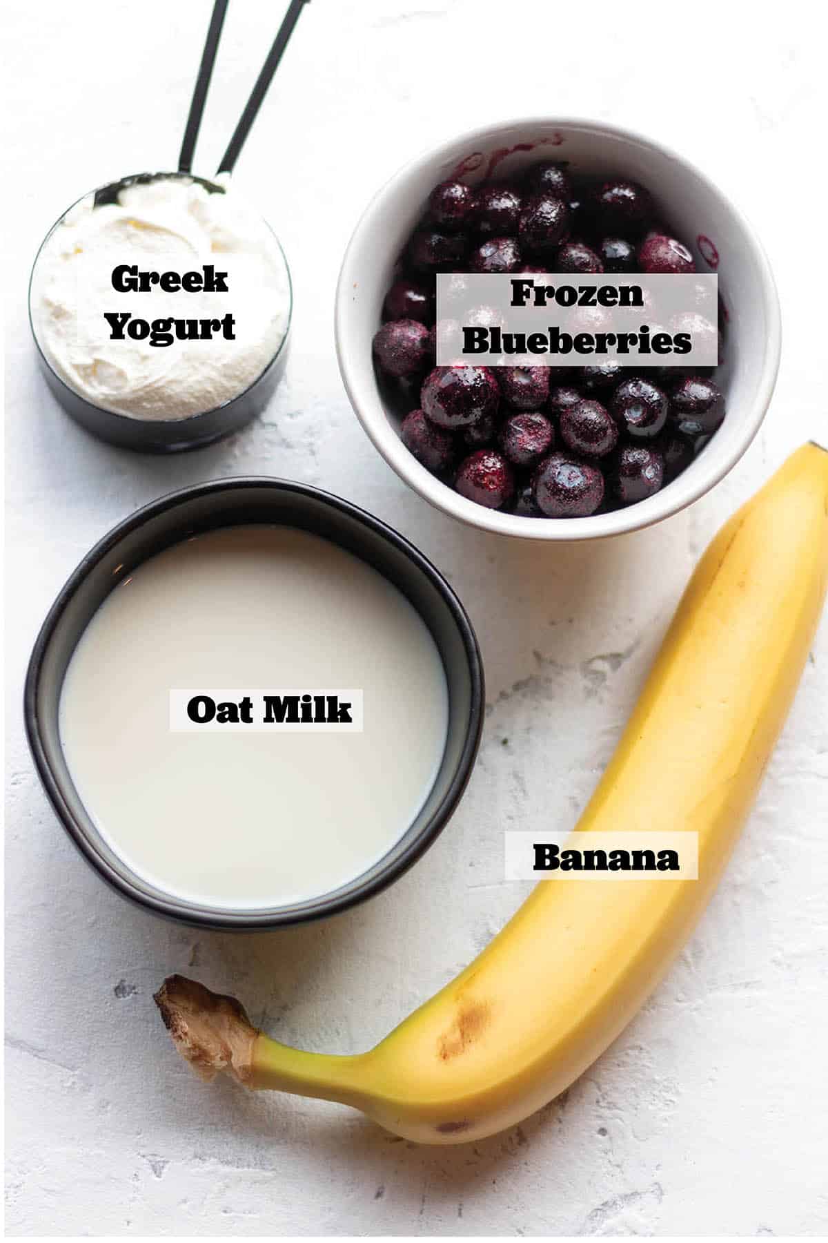 Greek Yogurt, oat milk, banana, and a bowl of blueberries.