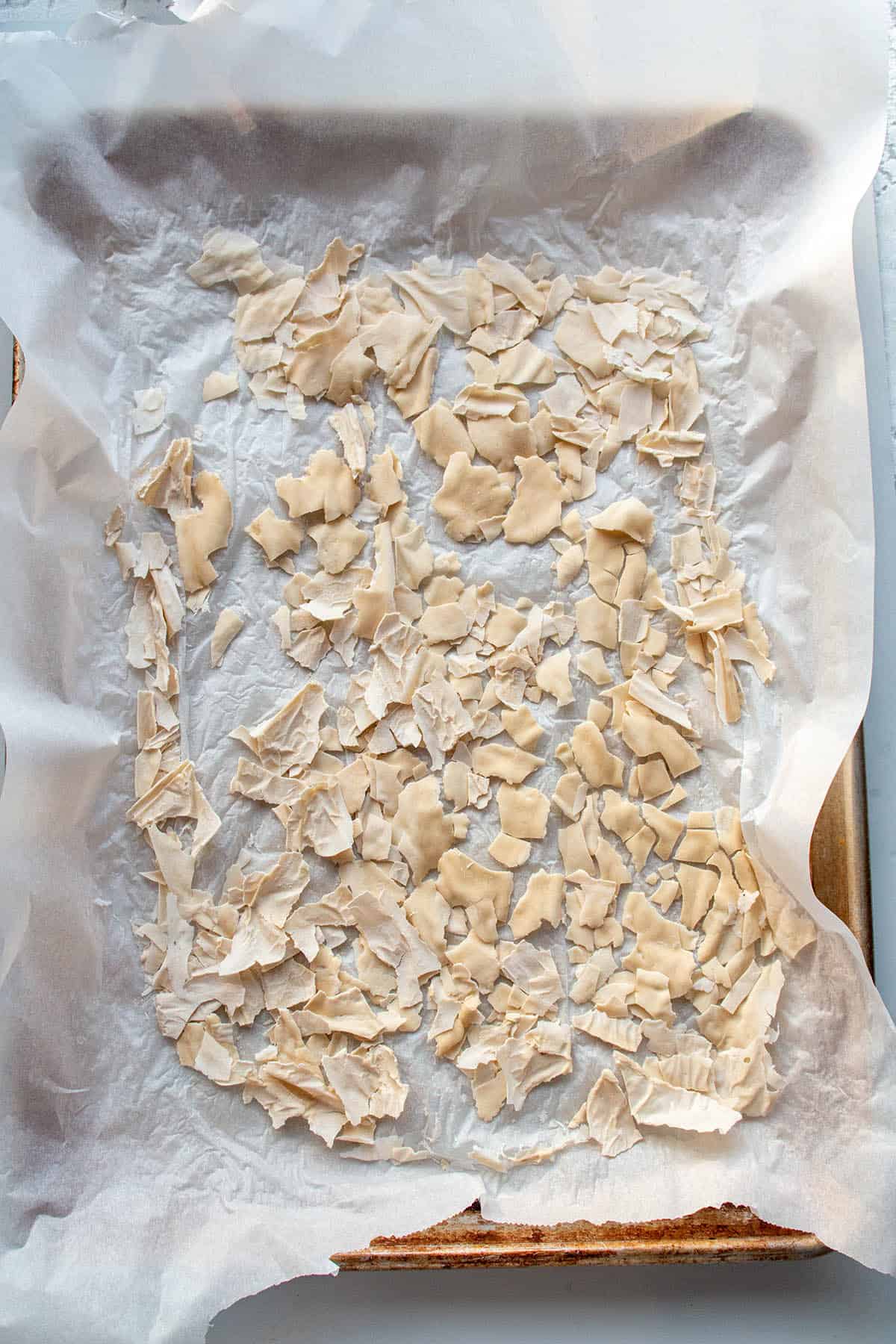 A baking sheet with parchment paper and dehydrated sourdough starter.