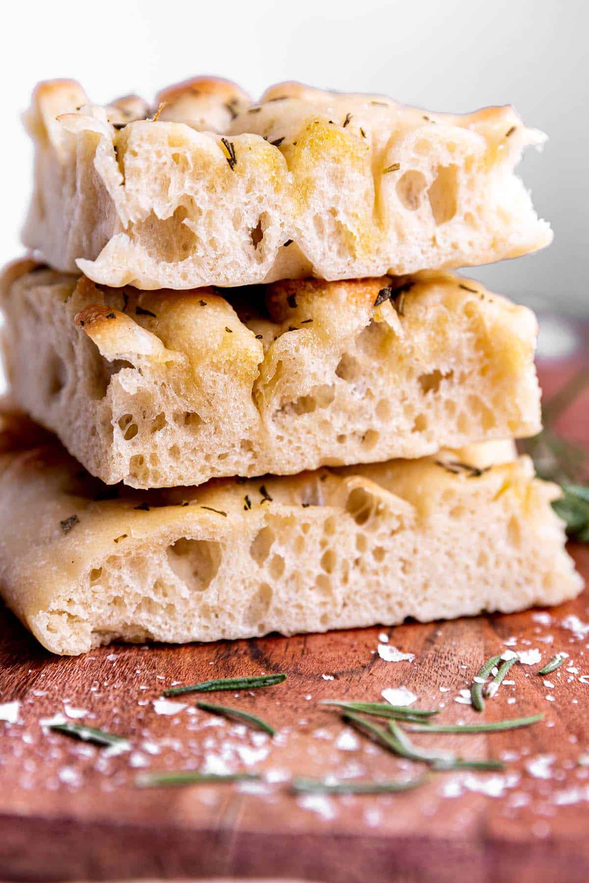 A stack of focaccia bread on a wooden board.