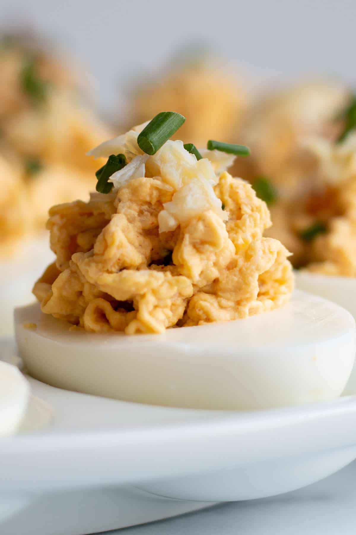 A deviled egg topped with fresh crab and chives.
